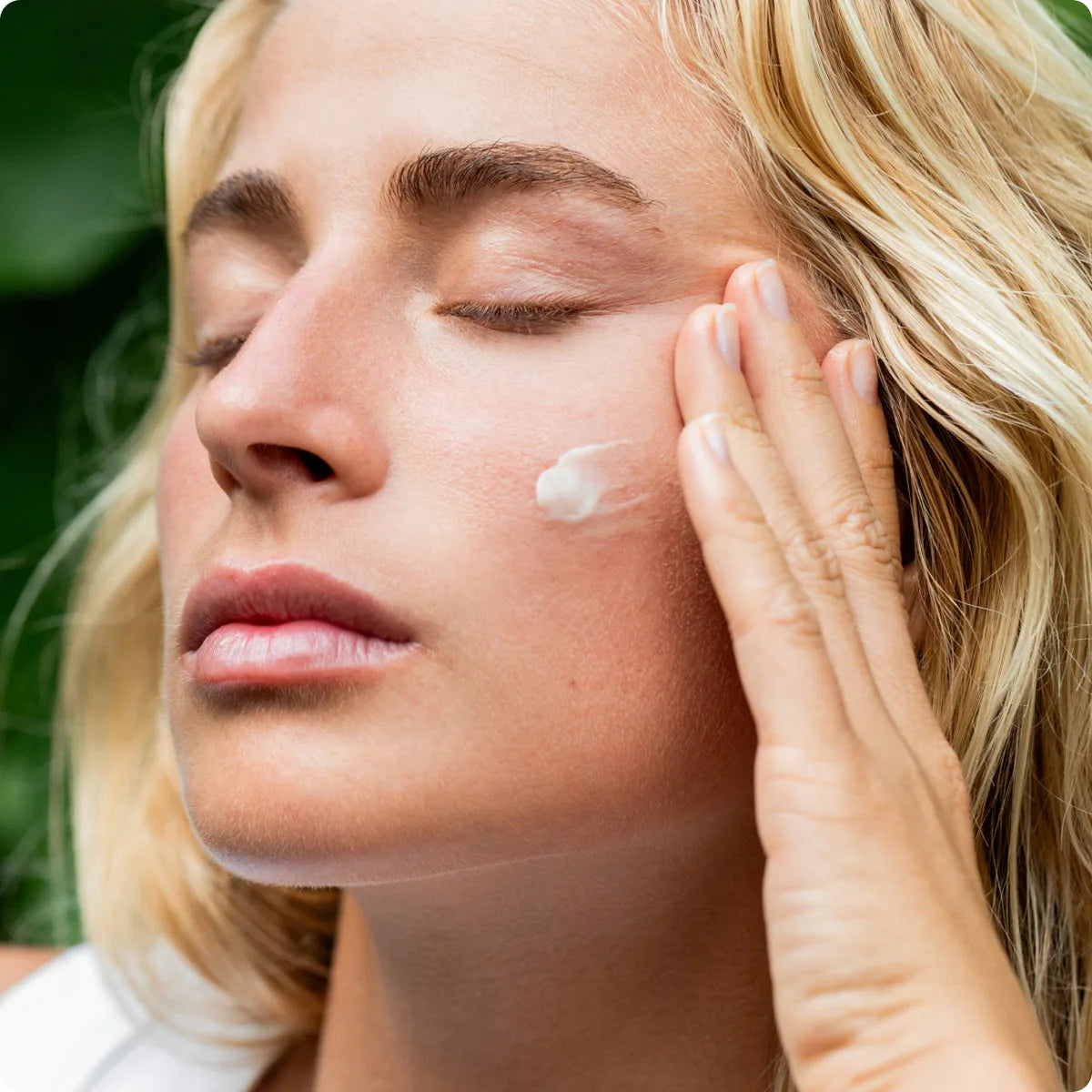 Mulher passando o Tallow Balm True Paleo no rosto
